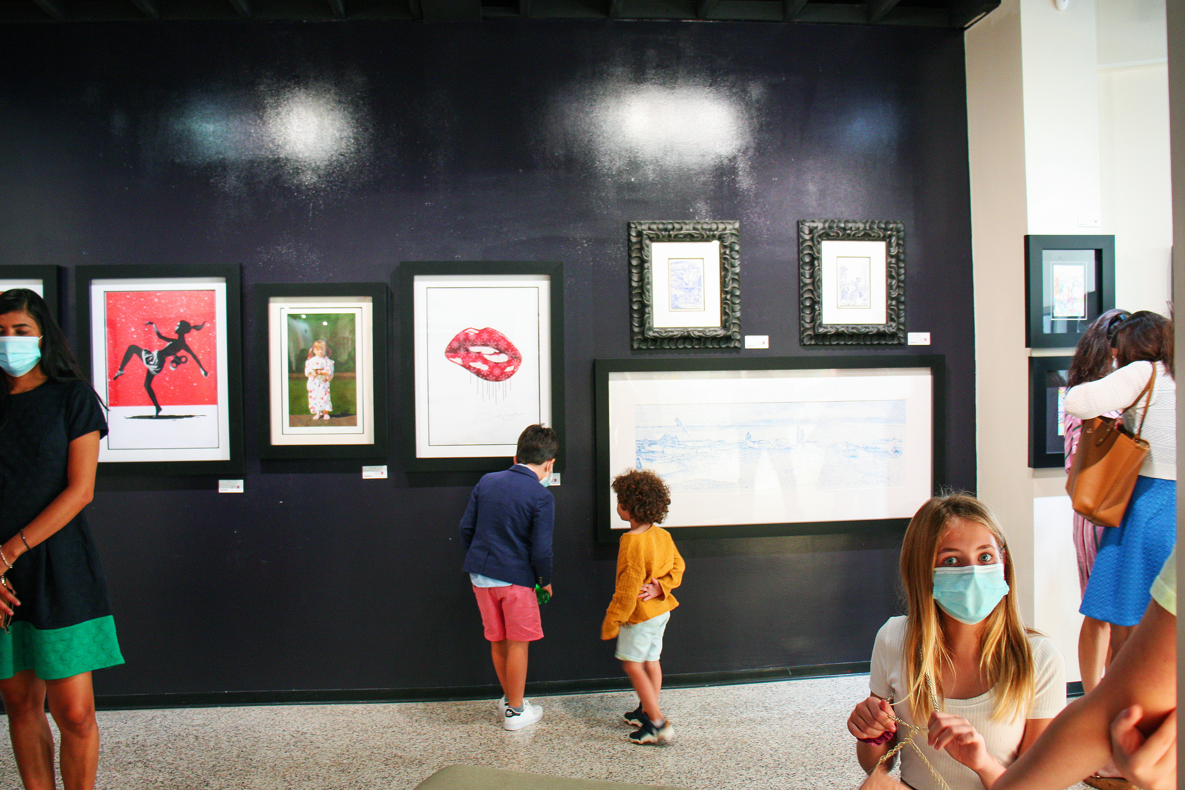 Exhibit visitors examine art in gallery