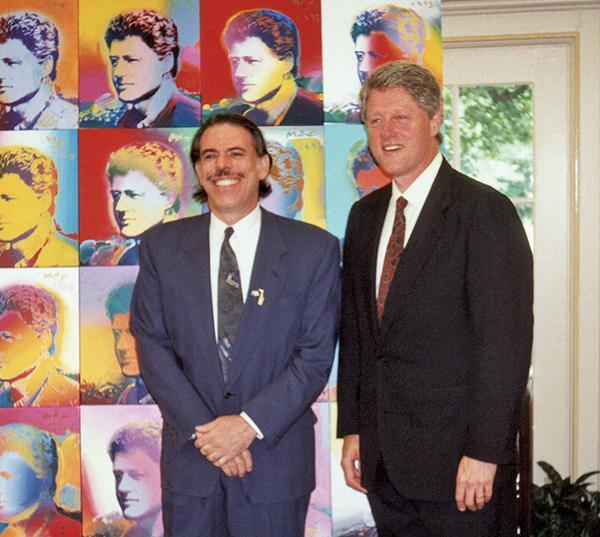 Peter Max with Bill Clinton in front of his portraits of Bill Clinton