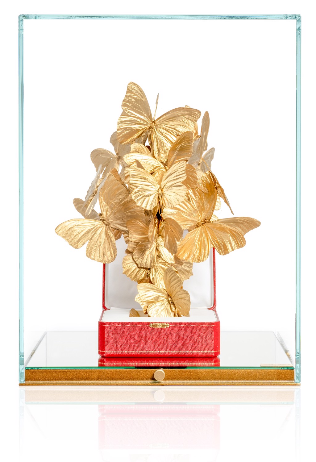 Roman Feral Cartier Gold: gold-colored butterflies rise above a red Cartier jewelry box inside a glass display with a mirrored base.