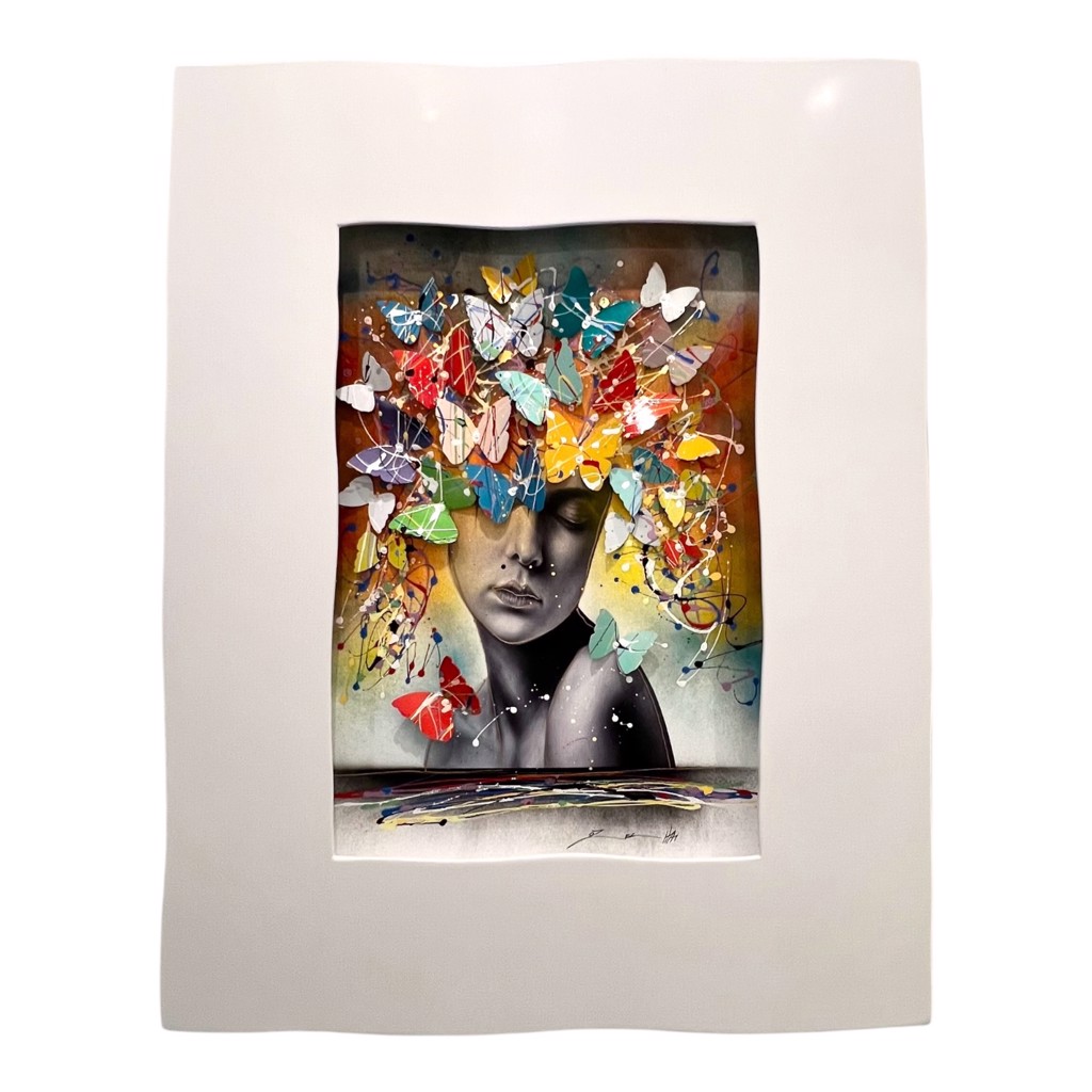 Oz El Hai The Beauty: grayscale woman with closed eyes beneath colorful dimensional butterflies and looping paint marks in a white frame.