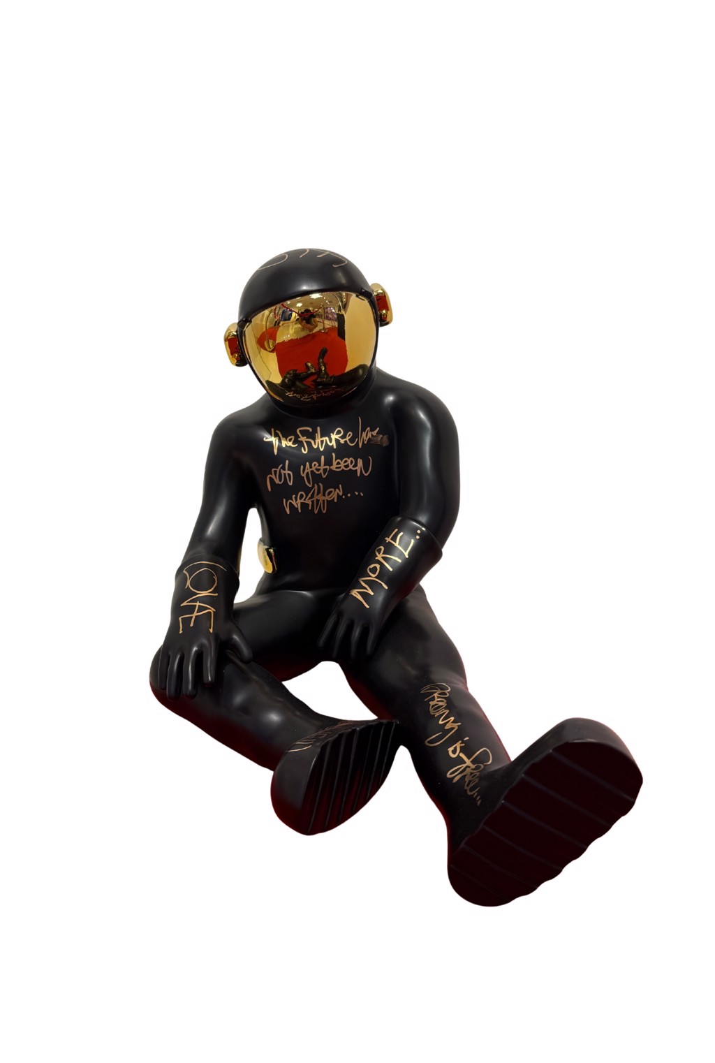 Brendan Murphy The Sitting Spaceman: black seated astronaut with extended legs, gold-colored handwriting, and reflective gold-toned visor.