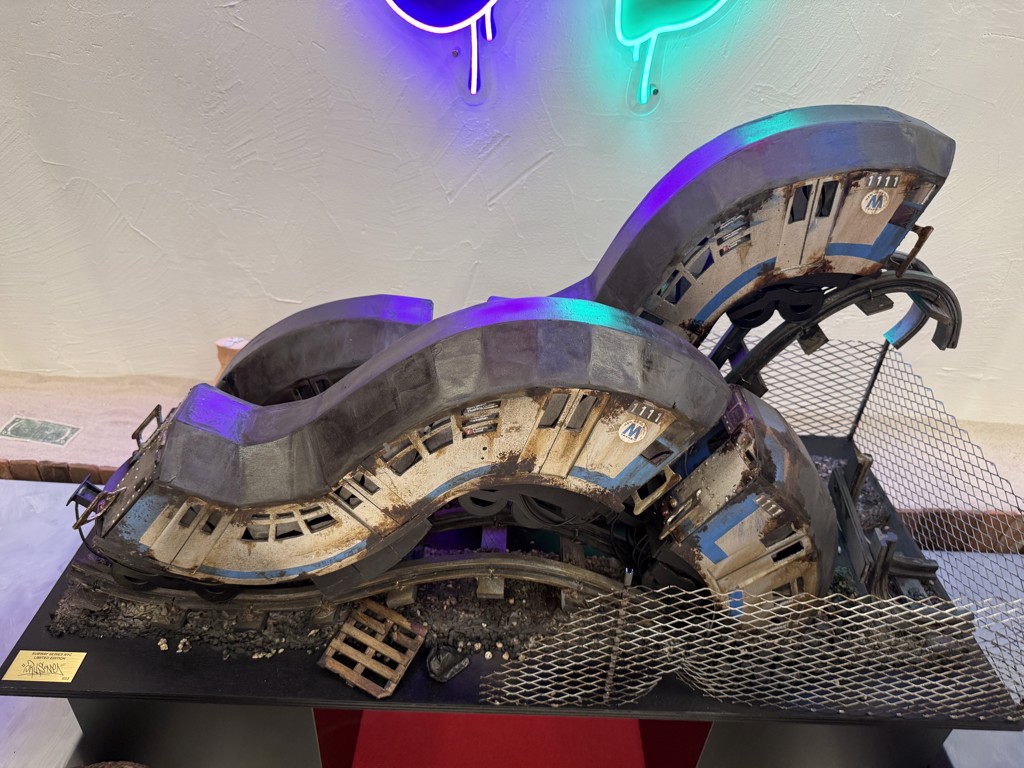 Orus Subway Series NYC Limited Edition #33: curving silver and beige subway cars above tracks and chain-link fencing on a black base.