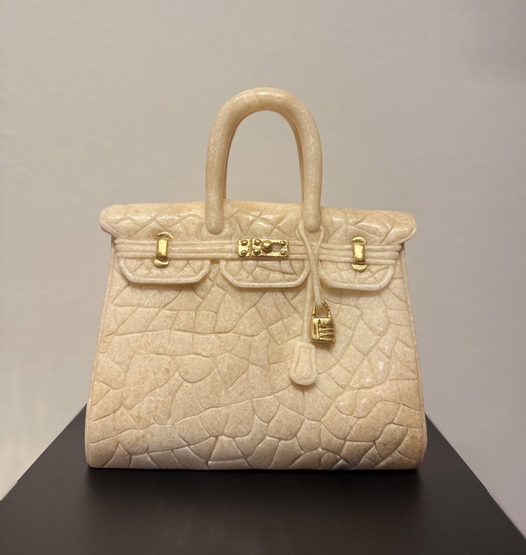 Ayden Snider Hermes Marble Birkin 25 YG: beige marble handbag sculpture with crocodile-pattern carving, rounded handles, and yellow-gold-toned hardware.