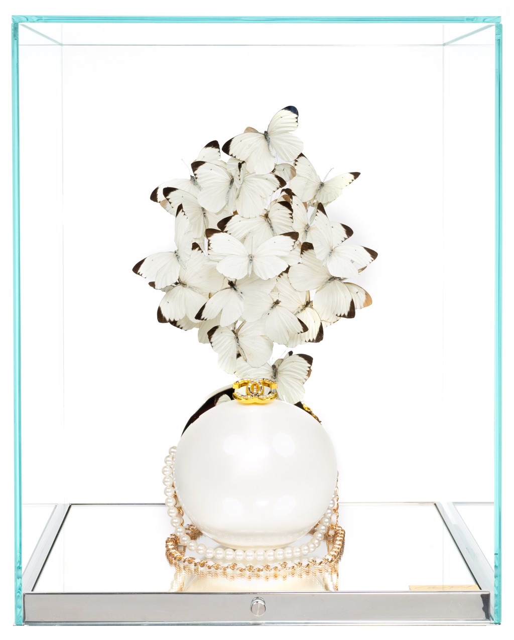 Roman Feral Chanel White Pearl Pure: white butterflies rise above a pearl-shaped Chanel bag inside a glass display case.