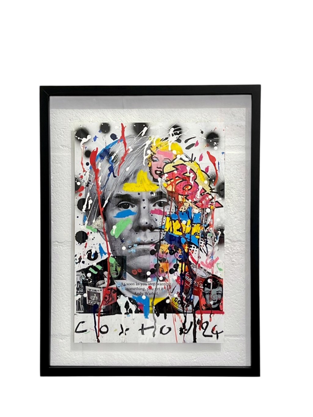 Andrew Cotton Warhol: Andy Warhol portrait beneath colorful graphic fragments, paint drips, and handwritten marks, shown in a black frame.