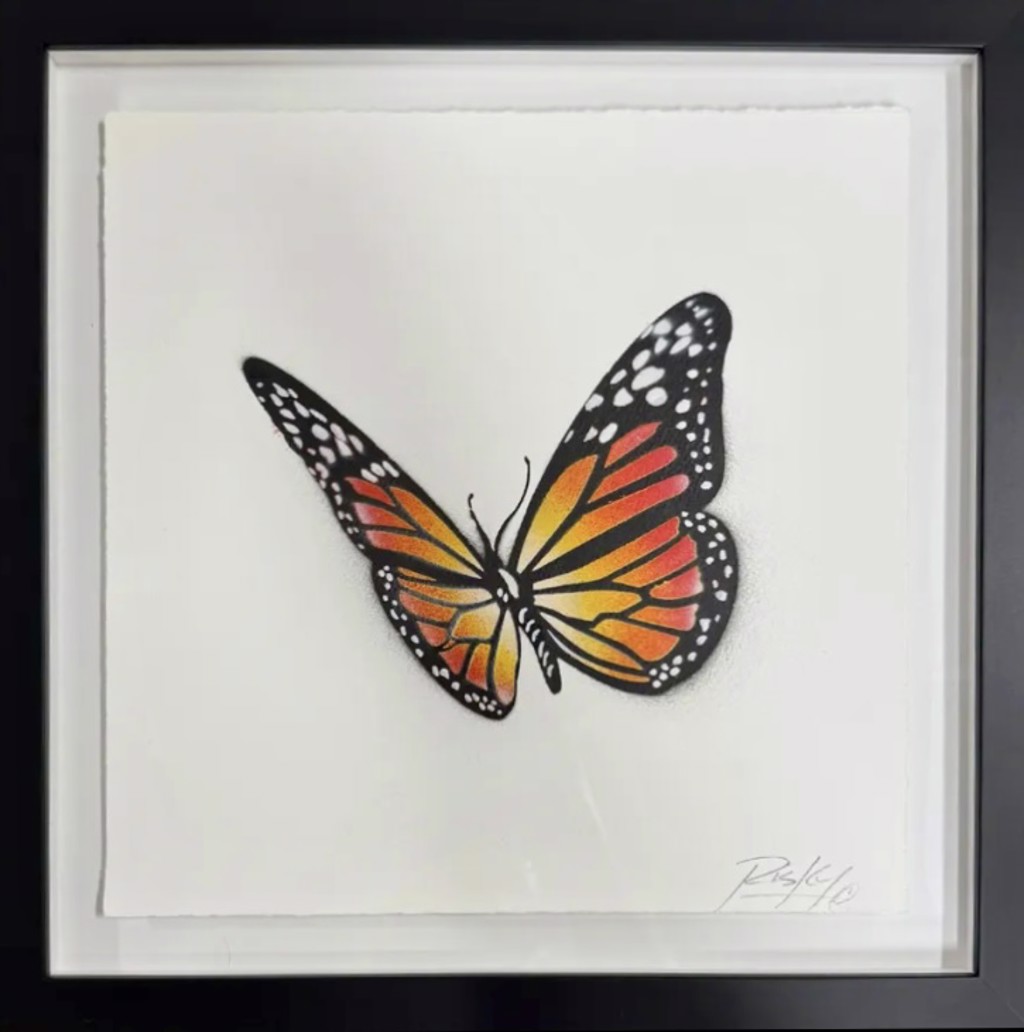 RISK, Monarch: orange and yellow butterfly on pale deckled paper in a black frame.
