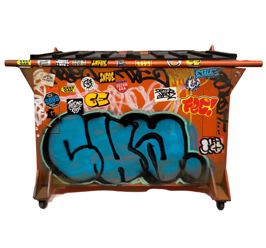 Danny Cortes Orange Dumpster: miniature orange dumpster with black lid, turquoise graffiti lettering, and layered stickers.
