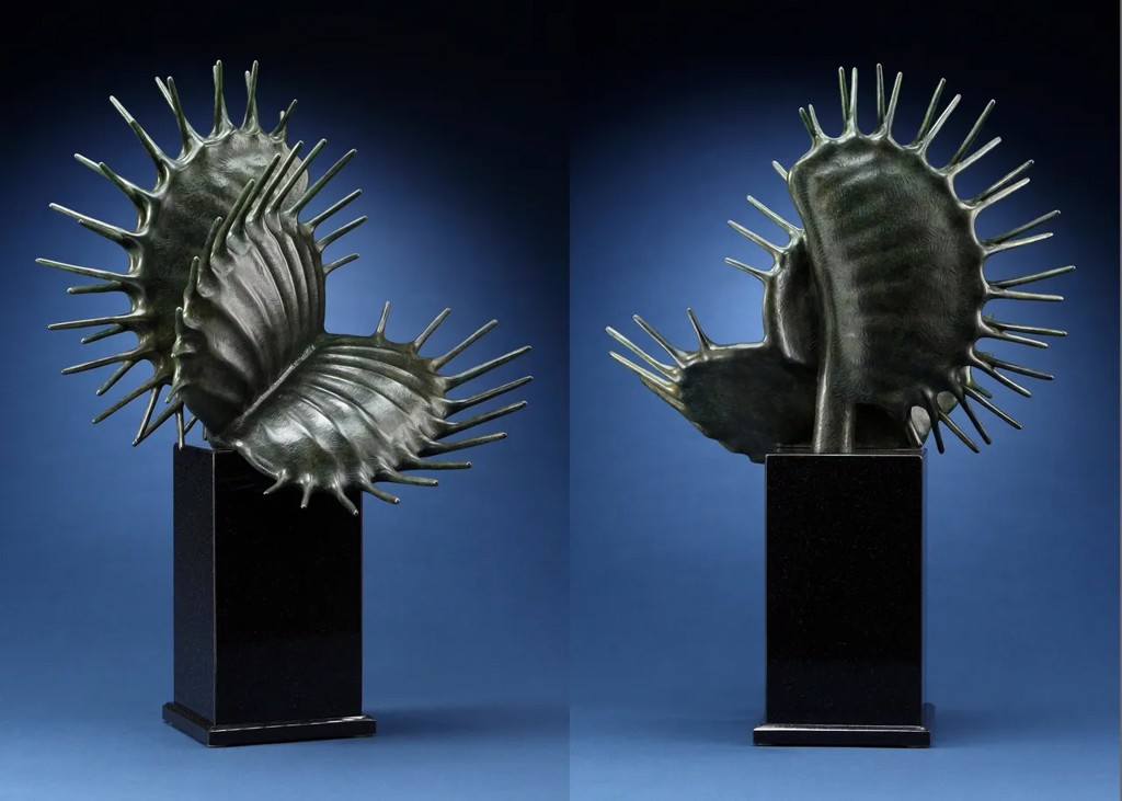 Bronze sculpture by Tony Hochstetler depicting a Venus flytrap plant with intricate, spiked leaves on a black pedestal, set against a dark blue background