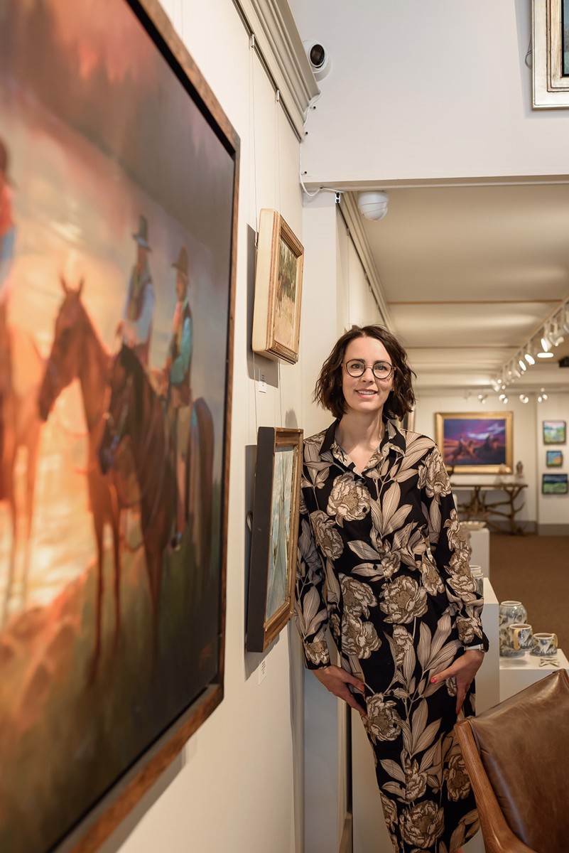 Michelle beside a large painting in the gallery