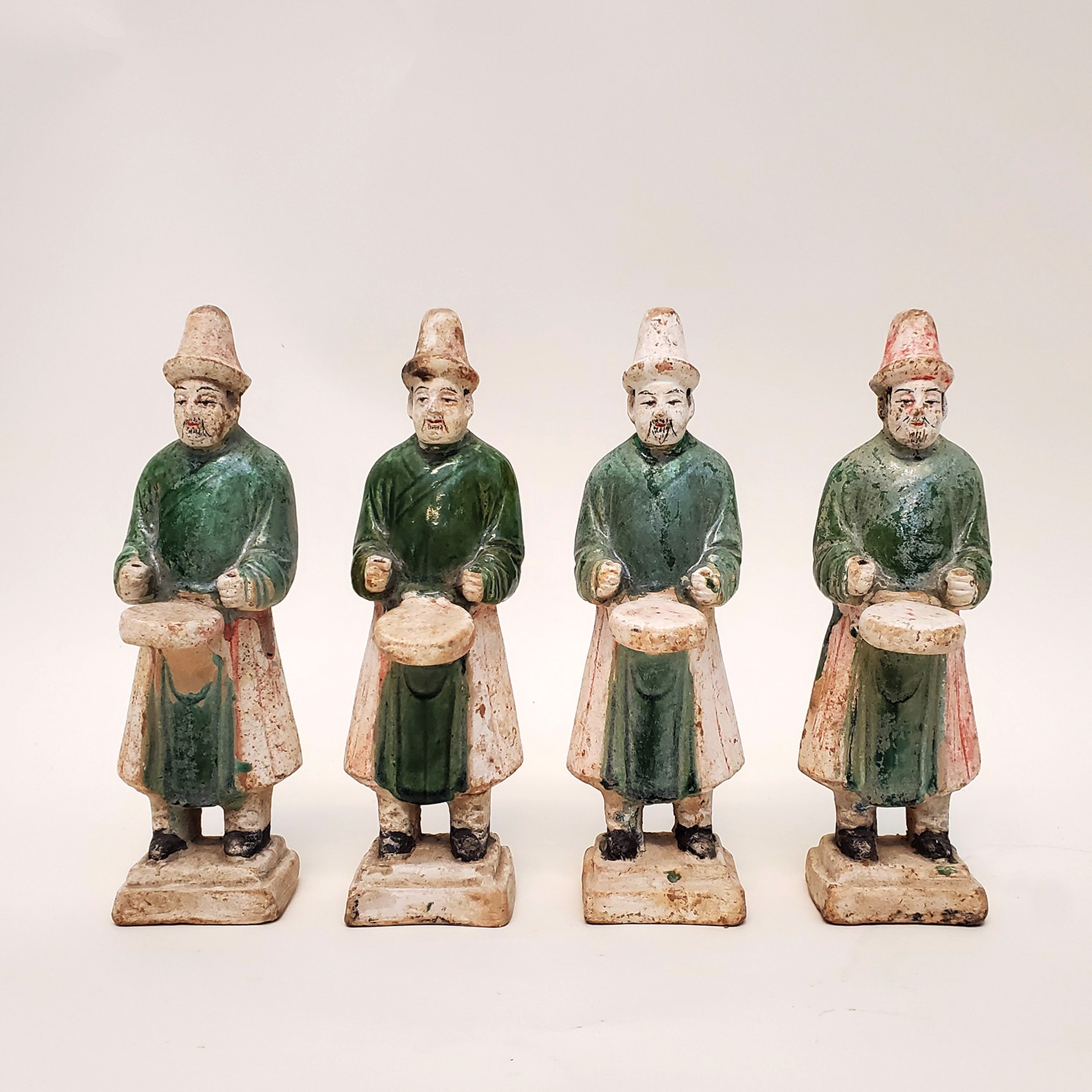 SET OF FOUR GREEN-GLAZED DRUMMERS