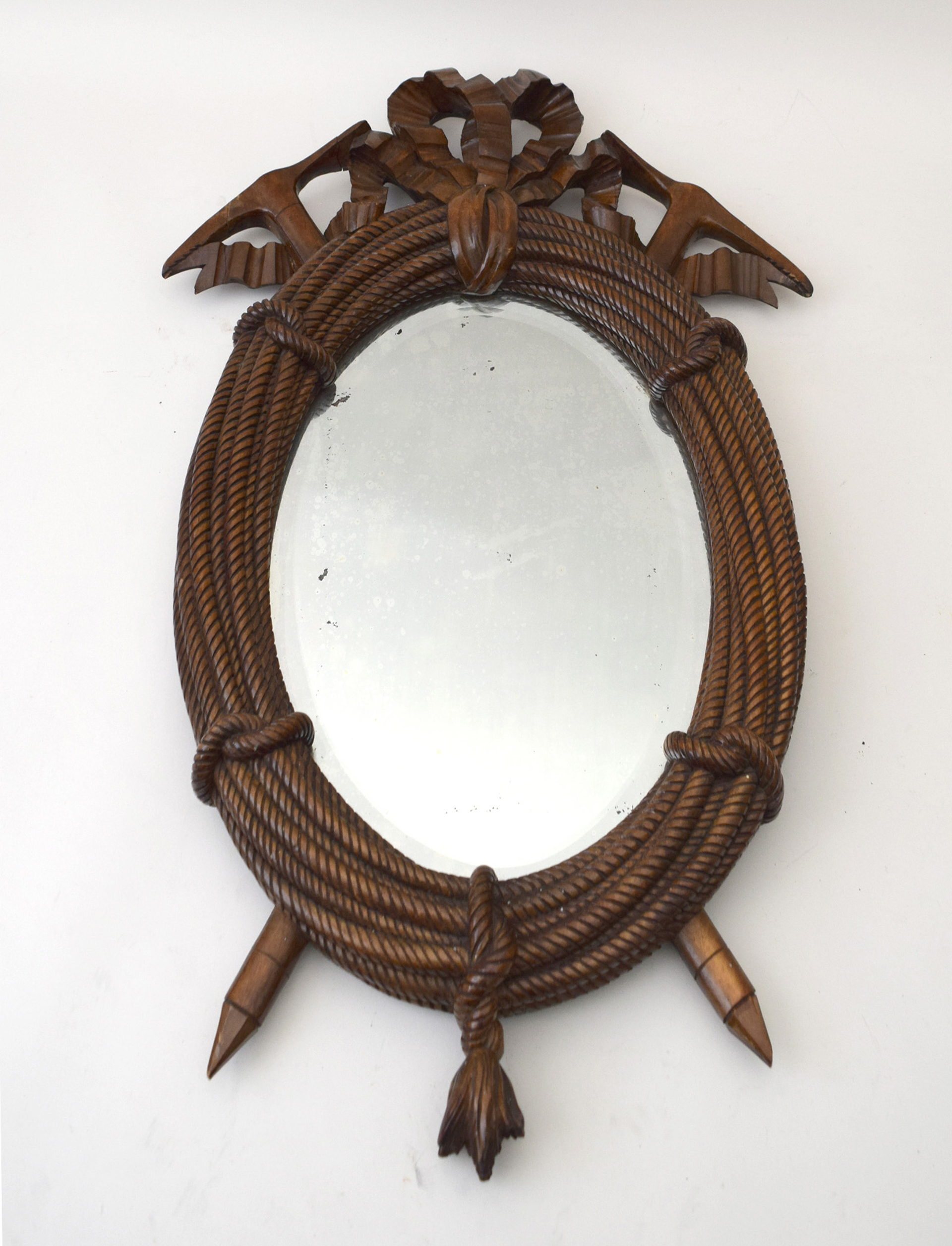 SMALL OVAL MIRROR CARVED WITH BOW-TIED COILED ROPE AND CROSSED PICK AXES