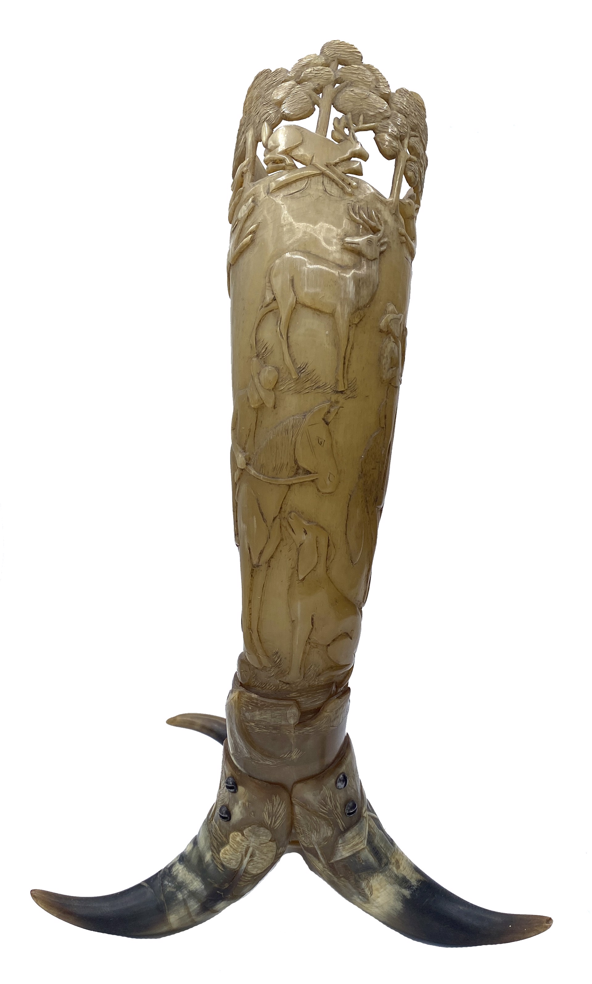 DS-84: carved powder horn on three horn legs; main horn depicts pastoral farm scene with horse and rider, dog, deer and dog hunting scene, with trees encircling the rim of cup; two legs show homestead scene in landscape, third leg has coiled snake form by Dan Super