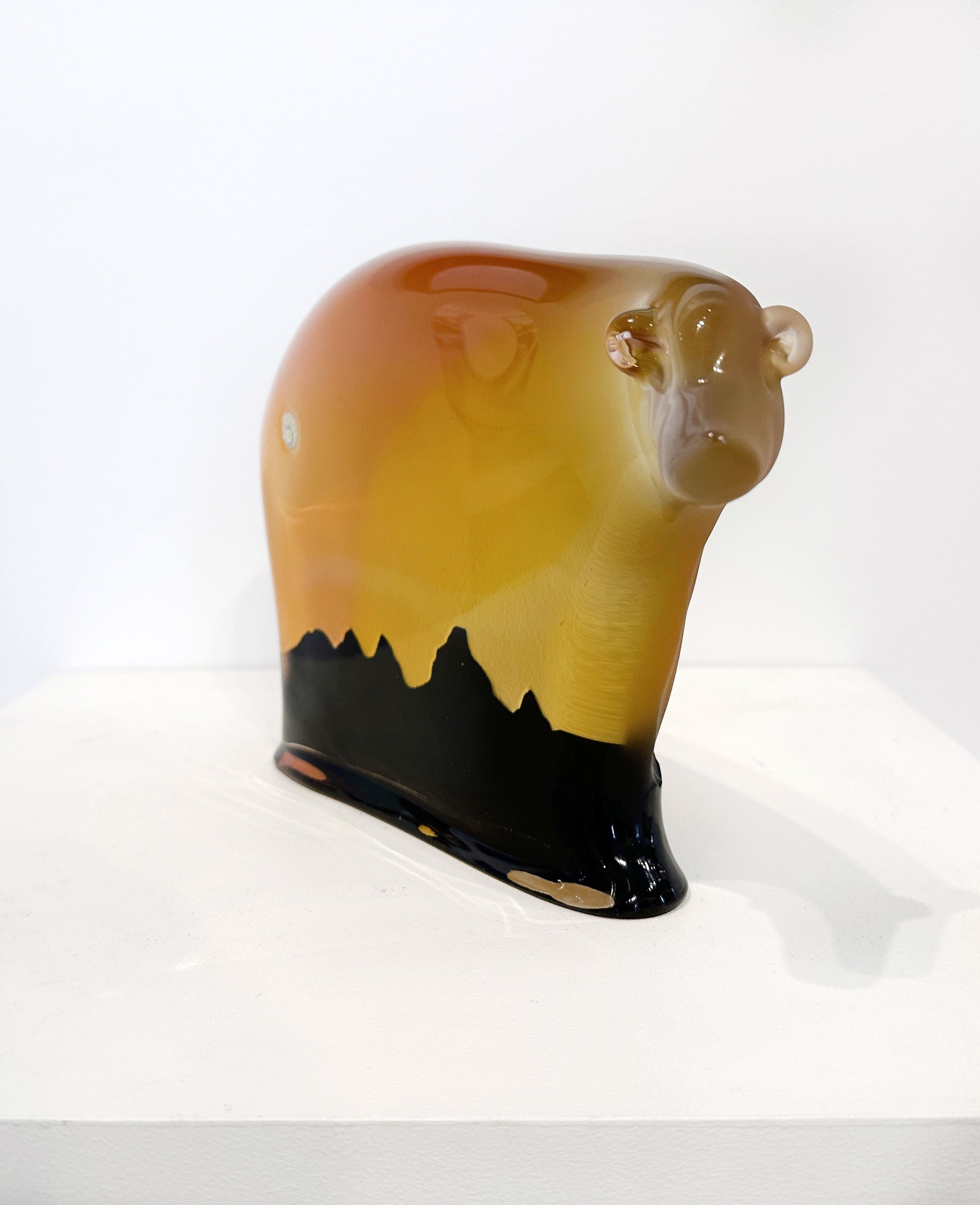 Original Glass Blow Sculpture By Dan Friday Featuring An Abstracted Bear Form In Orange To Yellow Gradient With The Teton Mountain Range Silhouette In Deep Purple