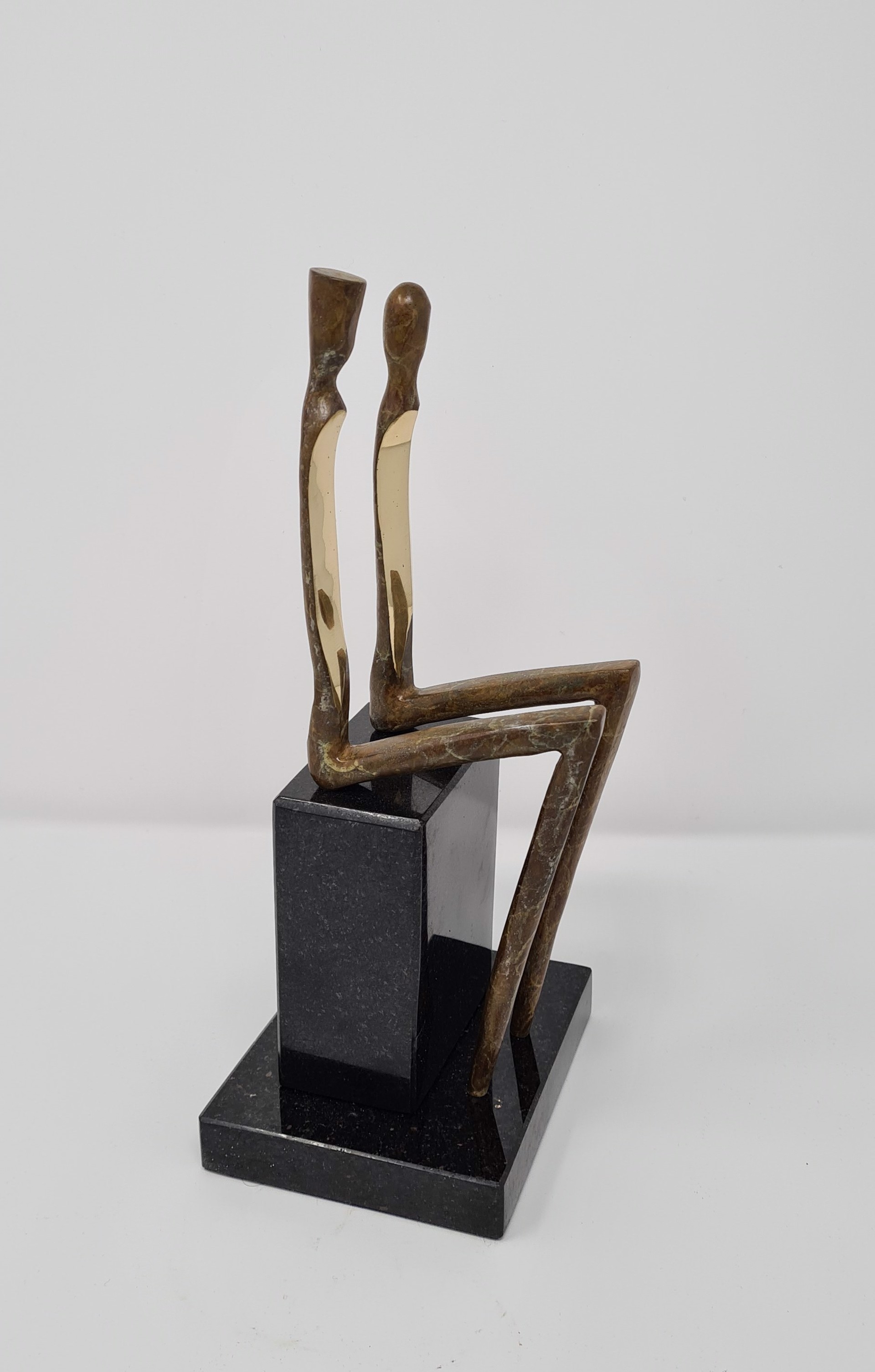 A bronze sculpture of a couple seated on a bench