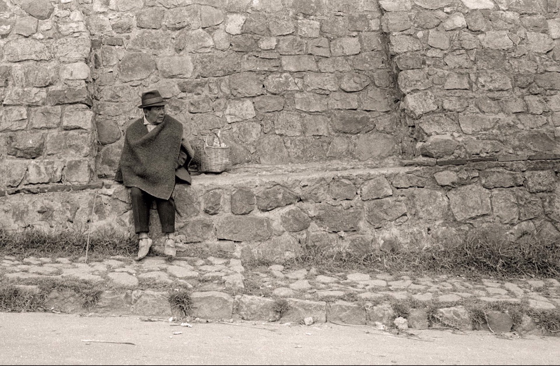 Man in Ruana Along a High Stone Wall by Jack Dempsey