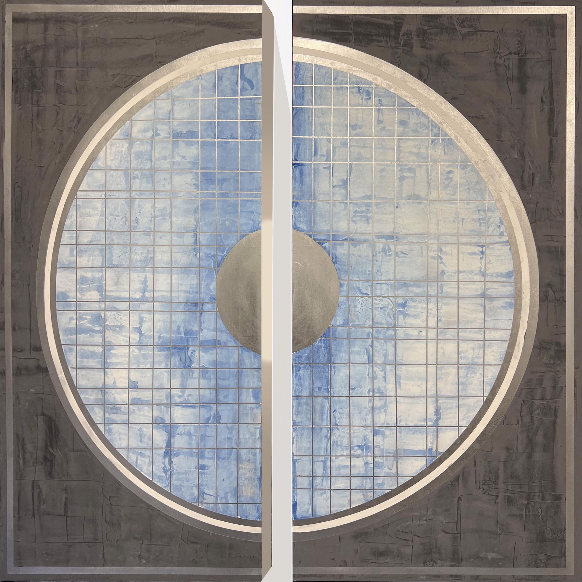 California artist and painter Stephanie Paige's 60"H x 60"W painting Quietude is a beautiful diptych made of two wood panels with layers of grey marble plaster paint and features a quilted textured circle with whites and blues.