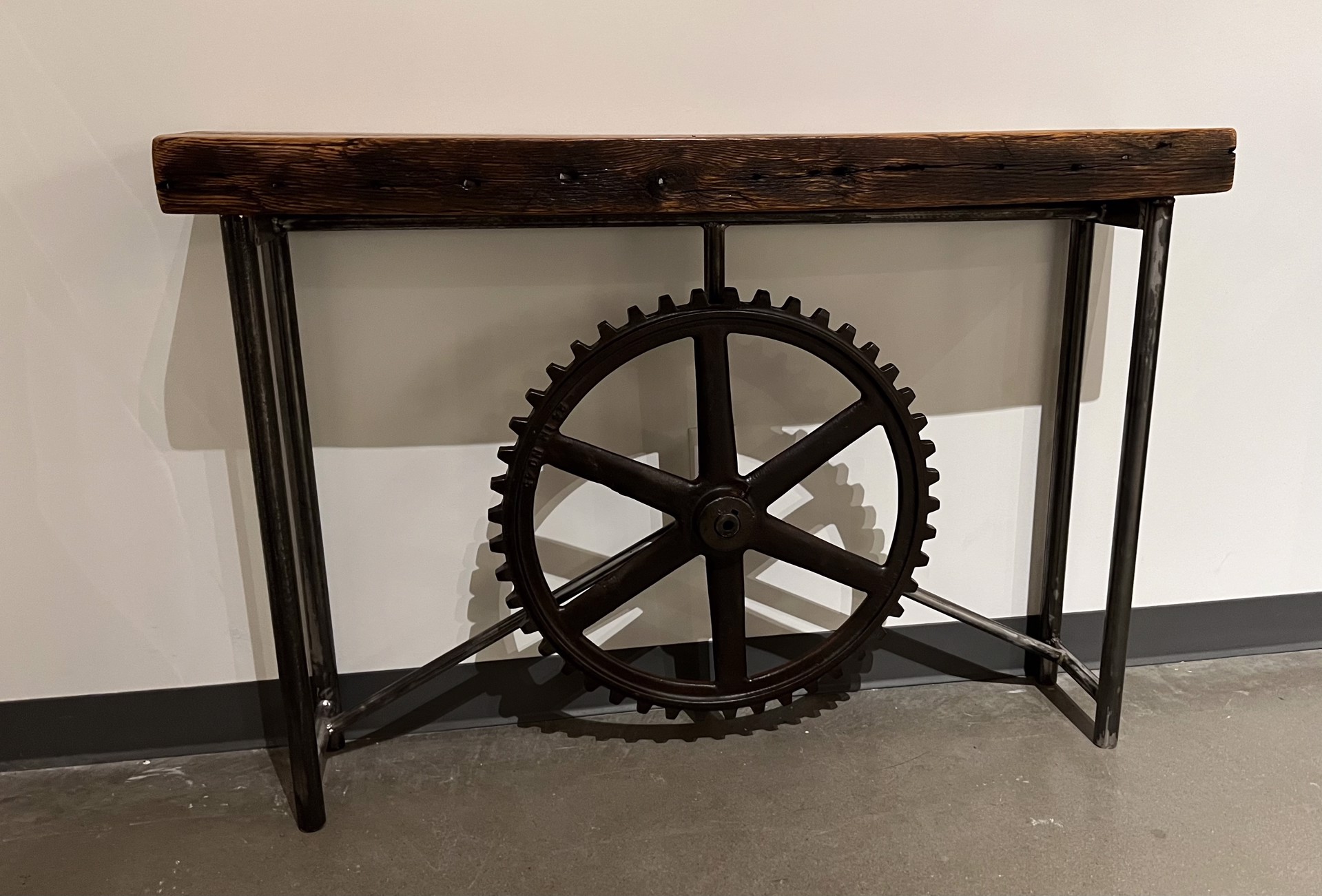 gear wheel and wood table by PAUL NELSON