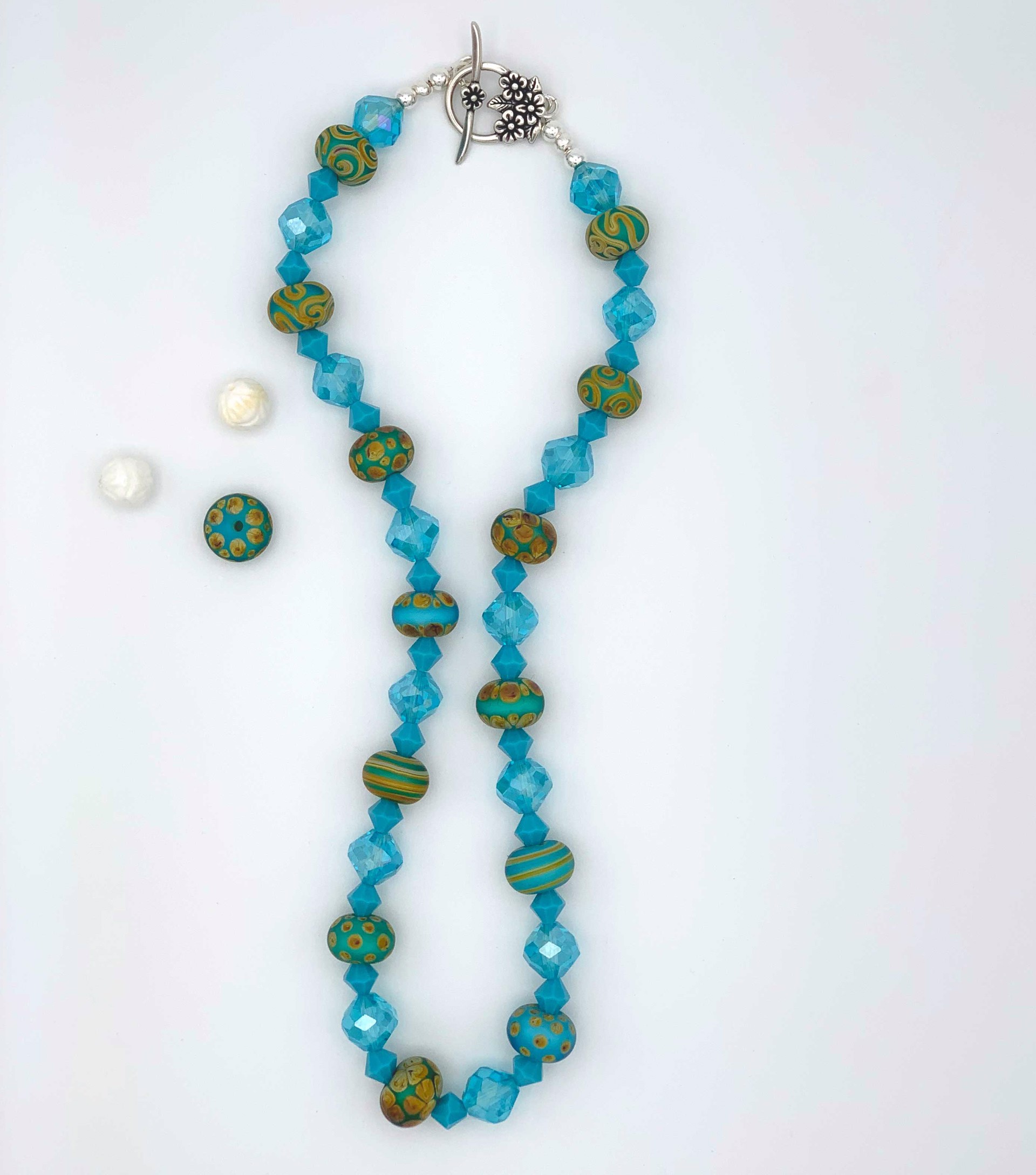 Beautiful blue Swarovski crystals and hand-torched glass beads, add a sea and sky appearance to this delightful necklace.