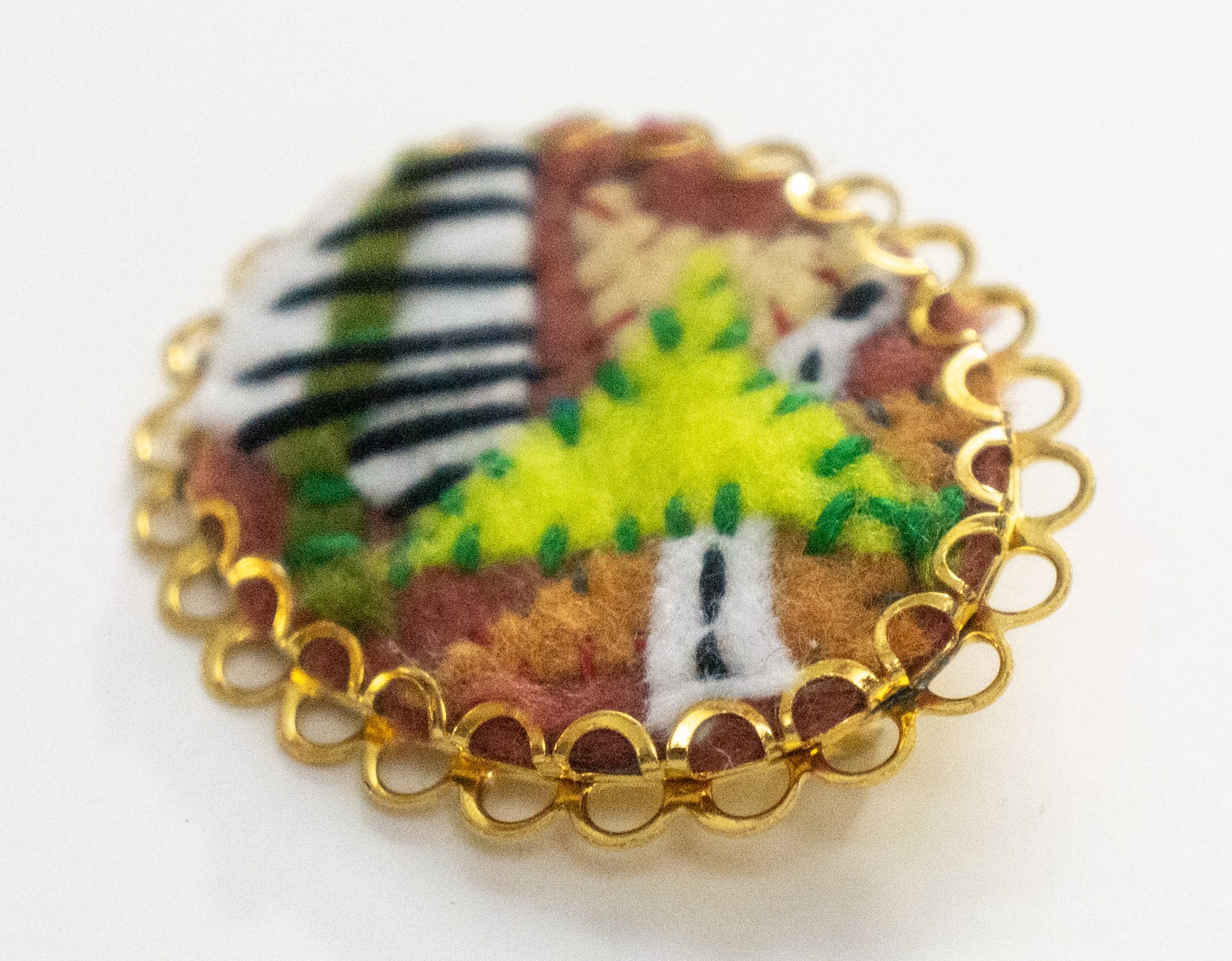 Green and striped brooch by Hattie Lee Mendoza