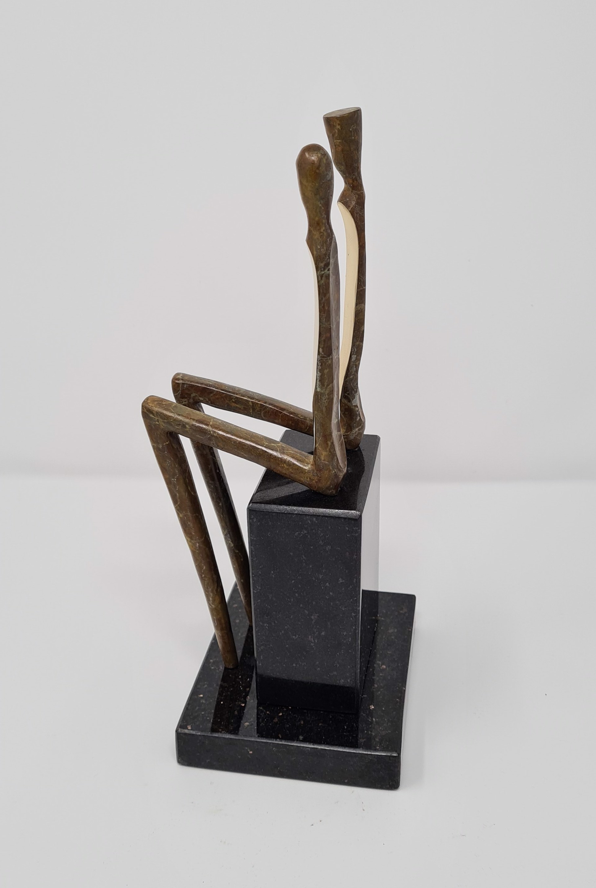 A bronze sculpture of a couple seated on a bench