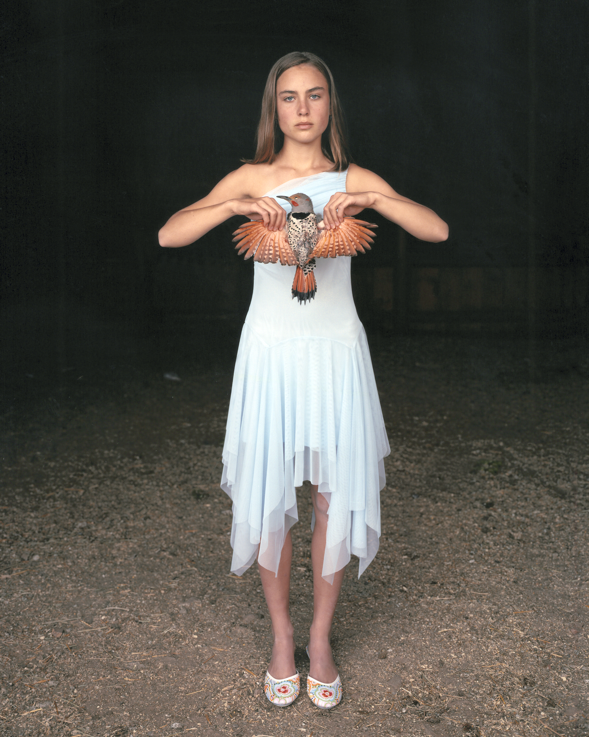 Mattie with a Northern Red-Shafted Flicker, in her Eighth Grade Graduation Dress, March 2005, Laverty Ranch, Idaho  AP by Laura McPhee