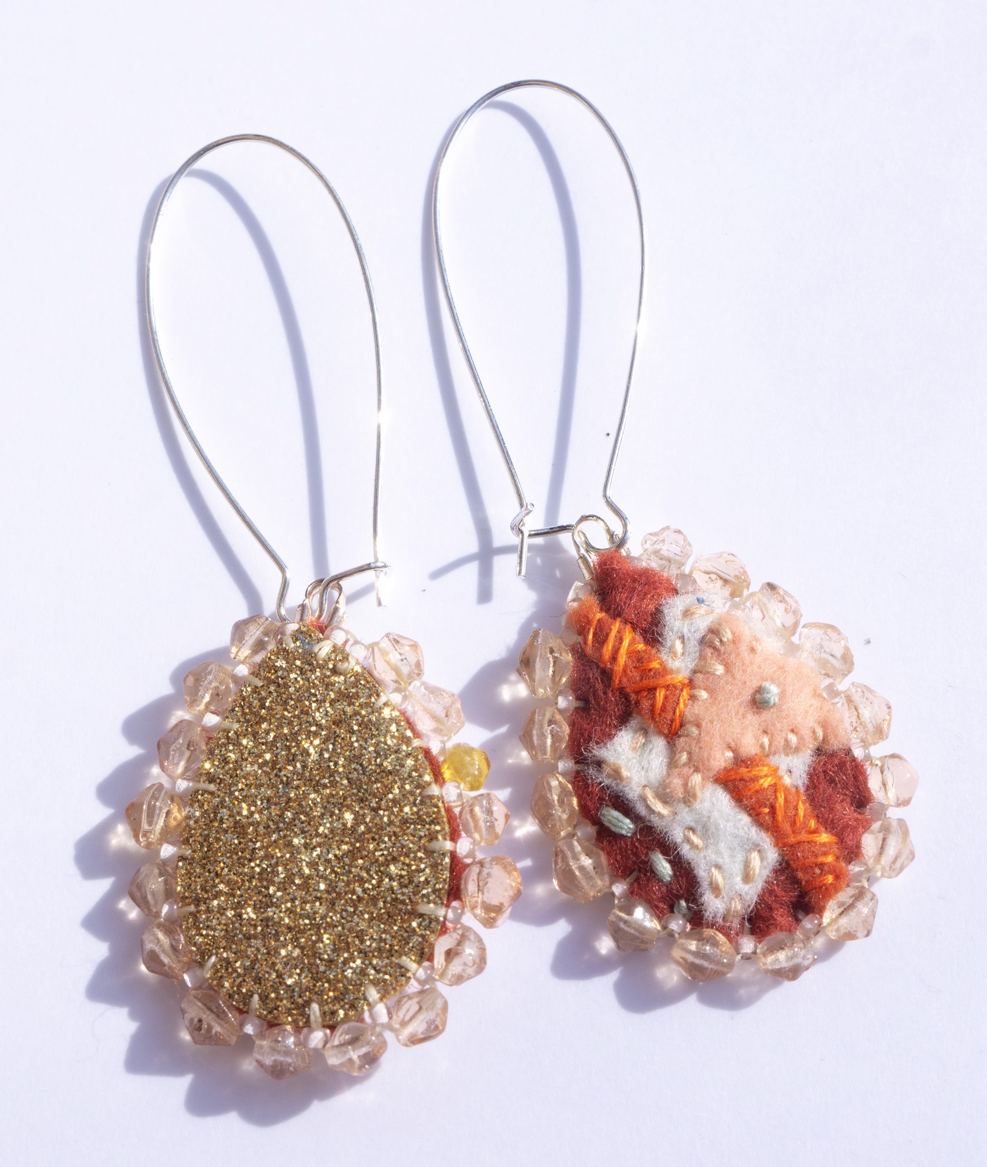 Orange embroidered earrings by Hattie Lee Mendoza