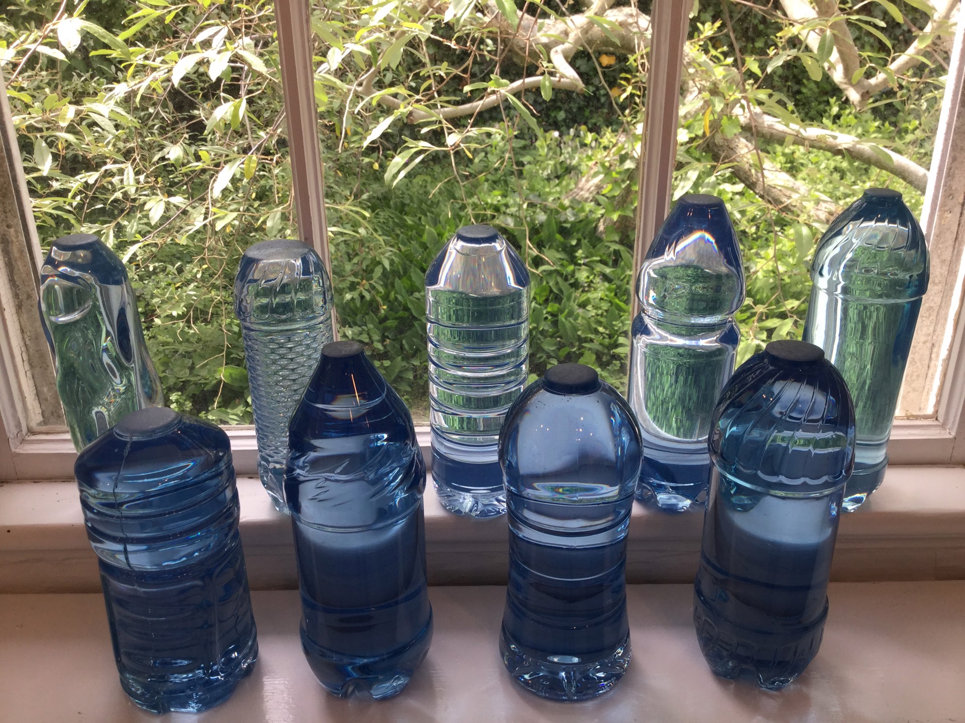 9 Cast plastic bottles by Robert Rindler