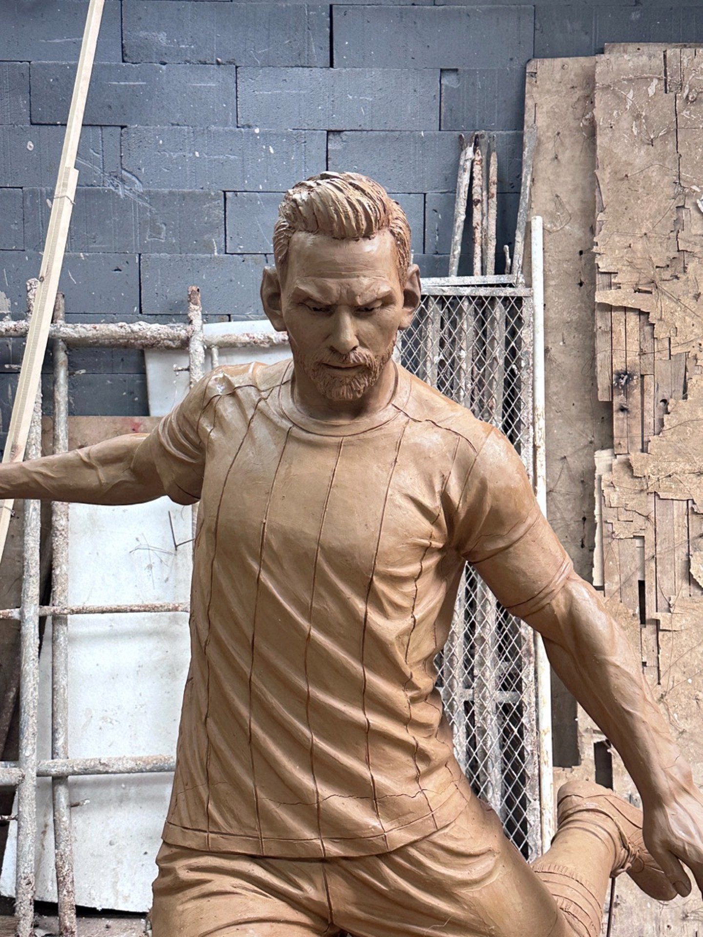 Frontal portrait detail of the Messi sculpture during clay development