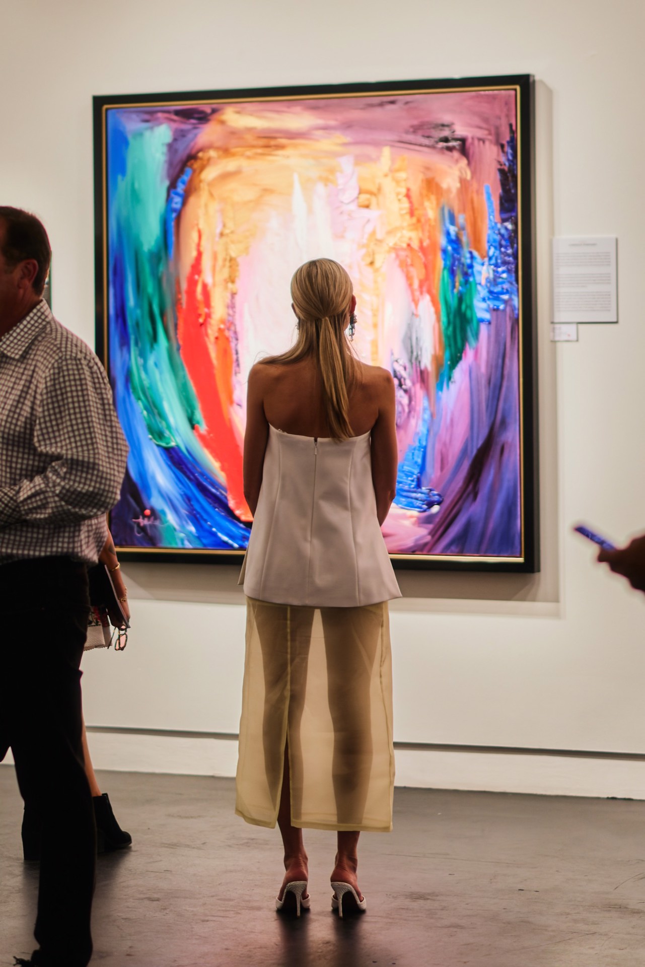 A guest viewing a large JD Miller painting on opening night of the Inaugural Reflectionist Exhibition at Samuel Lynne Galleries, Dallas, September 12, 2026