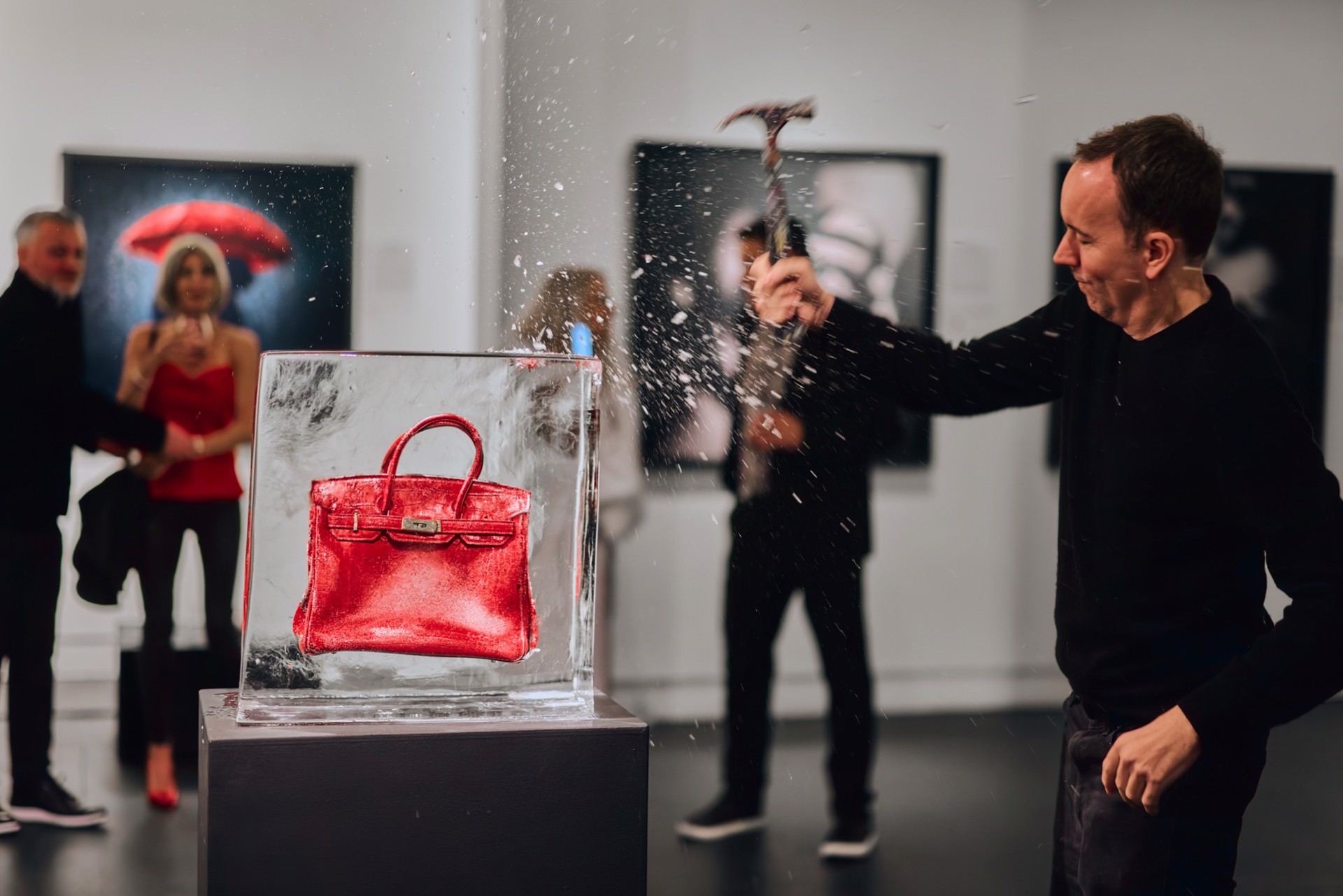 Tyler Shields breaking the ice around the red Birkin as guests look on at Samuel Lynne Galleries, Dallas