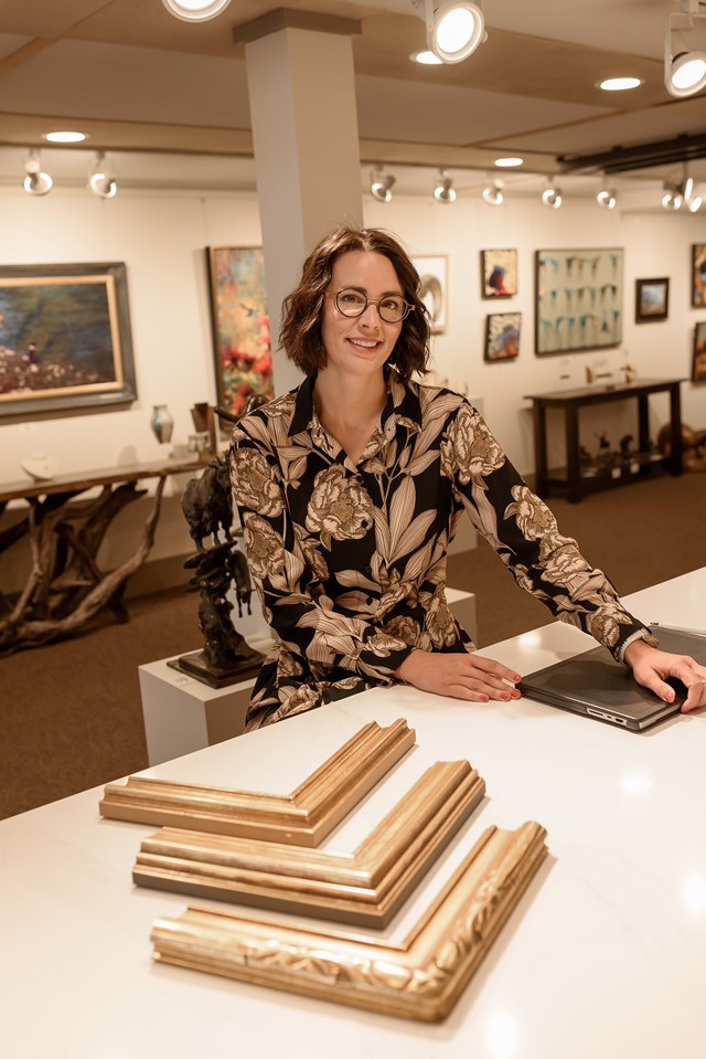 Michelle Cassens at the framing design counter with gold corner samples