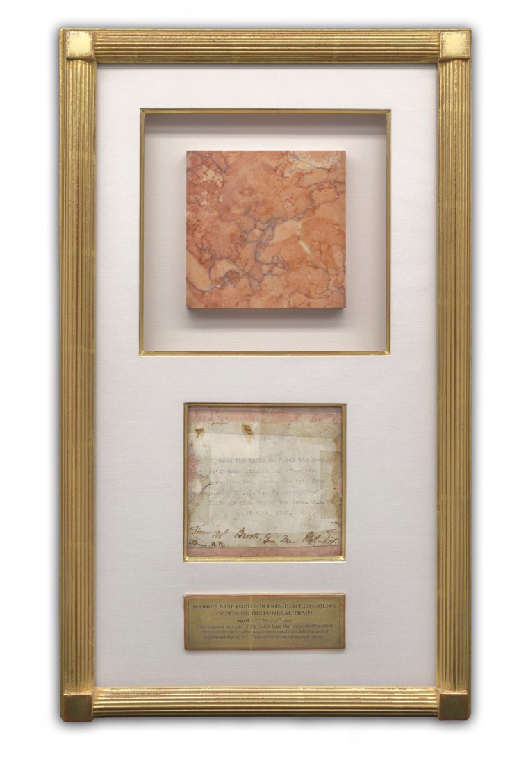The framed Lincoln marble fragment in its gold leaf shadowbox