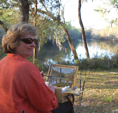 Artist Eleanor Blair paints en plen aire in front of a Florida lake